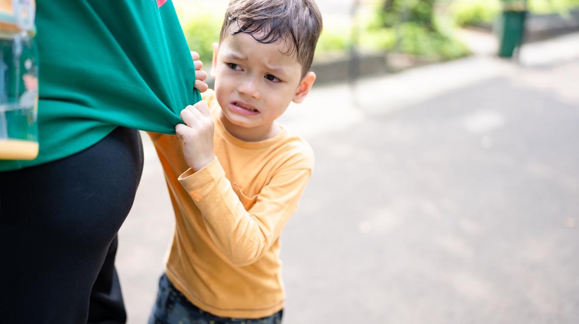 young boy tugging on his mother's shirt