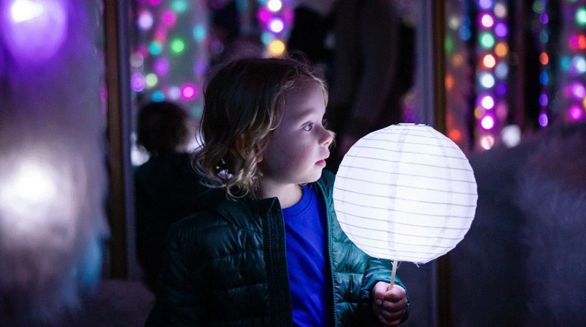 child holding a lantern on the Tacoma Light Trail, a holiday light experience