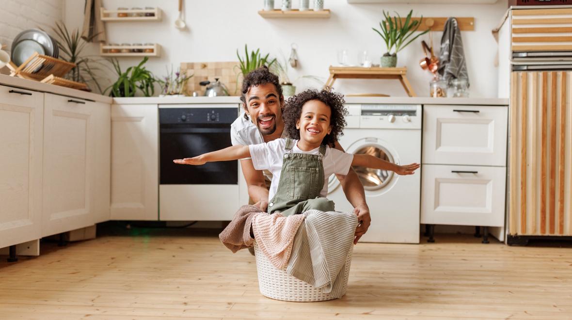 dad and child doing the laundry together having fun