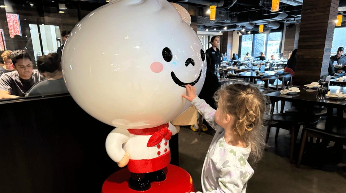 kid touching the mascot at Din Tai Fung in Seattle