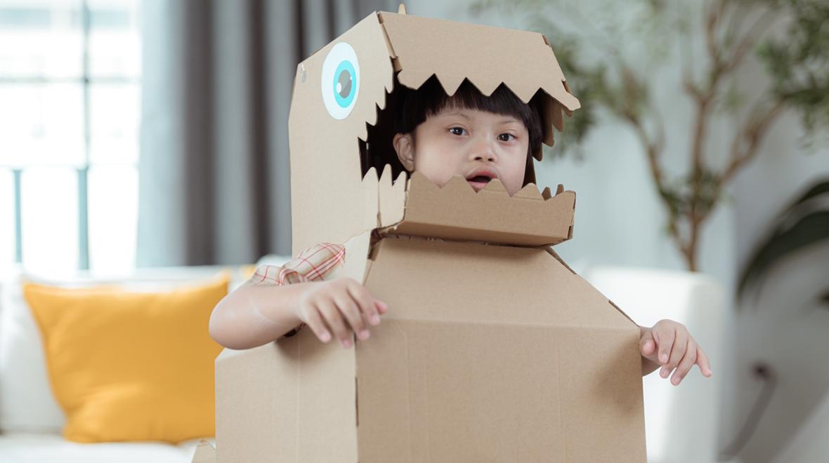 child in a cardboard dino costume