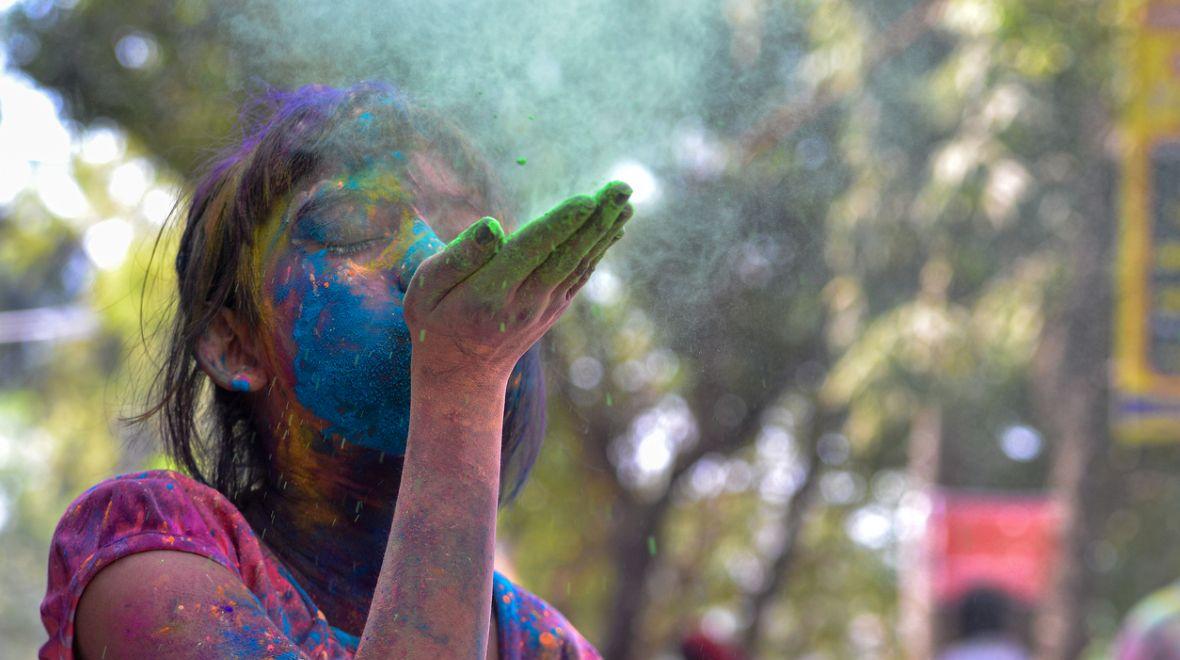 A-girl-blowing-colors-celebrating-holi-colors-best-seattle-area-Holi-events-kids-families-redmond-eastide