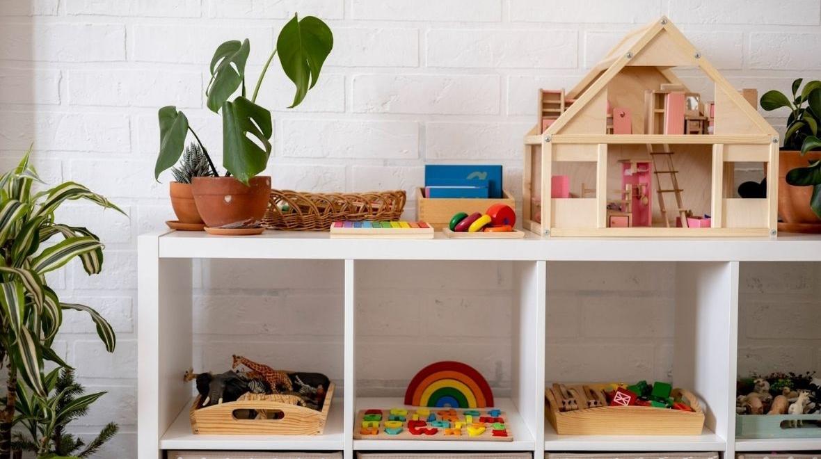 Montessori material white shelves in a room with neatly arranged toys
