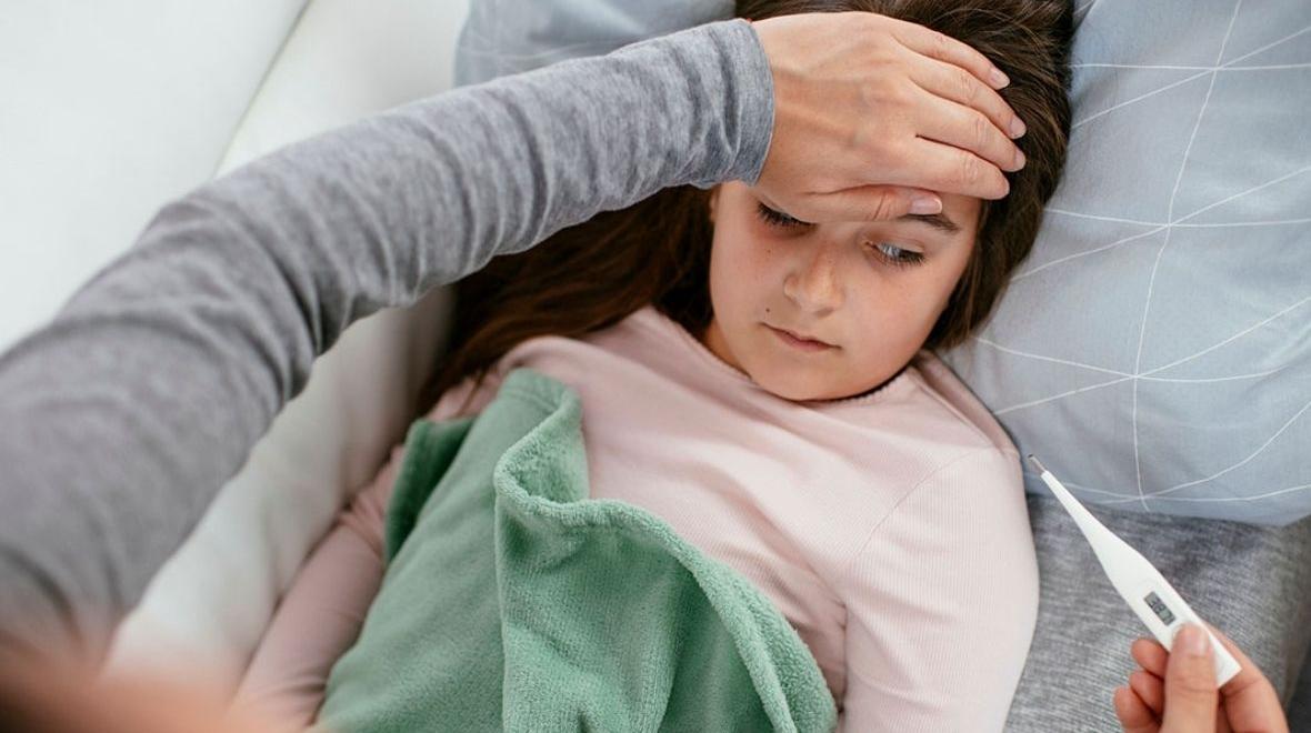 little girl sick checking body temperature with thermometer