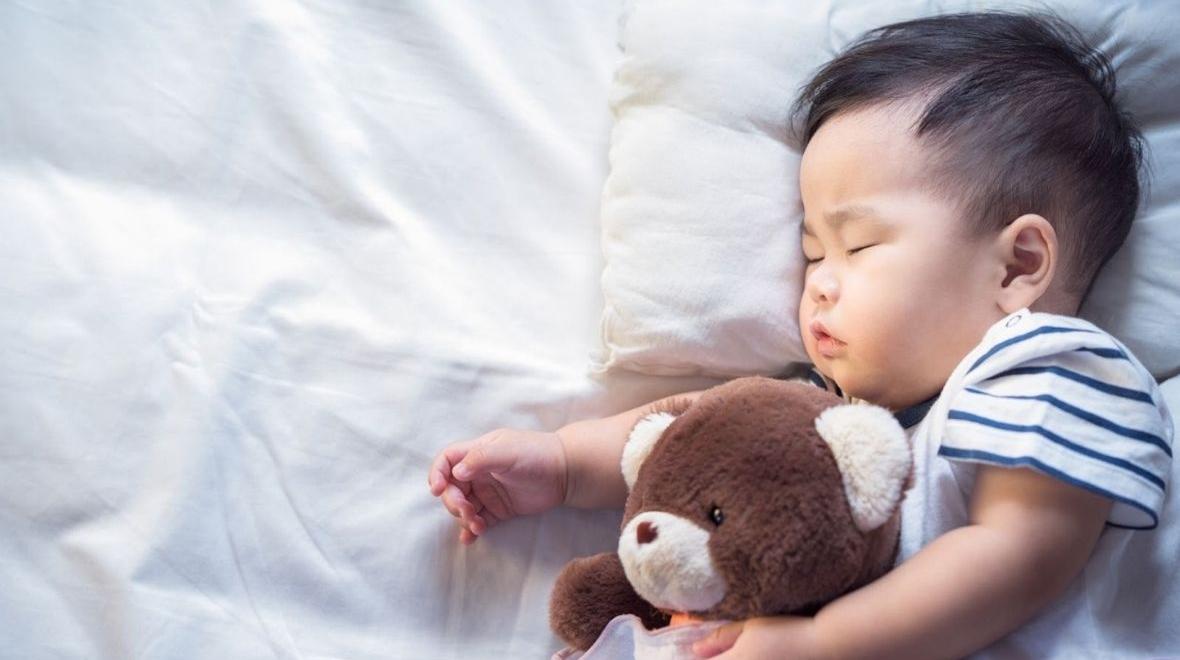 Newborn baby sleeping with teddy bear