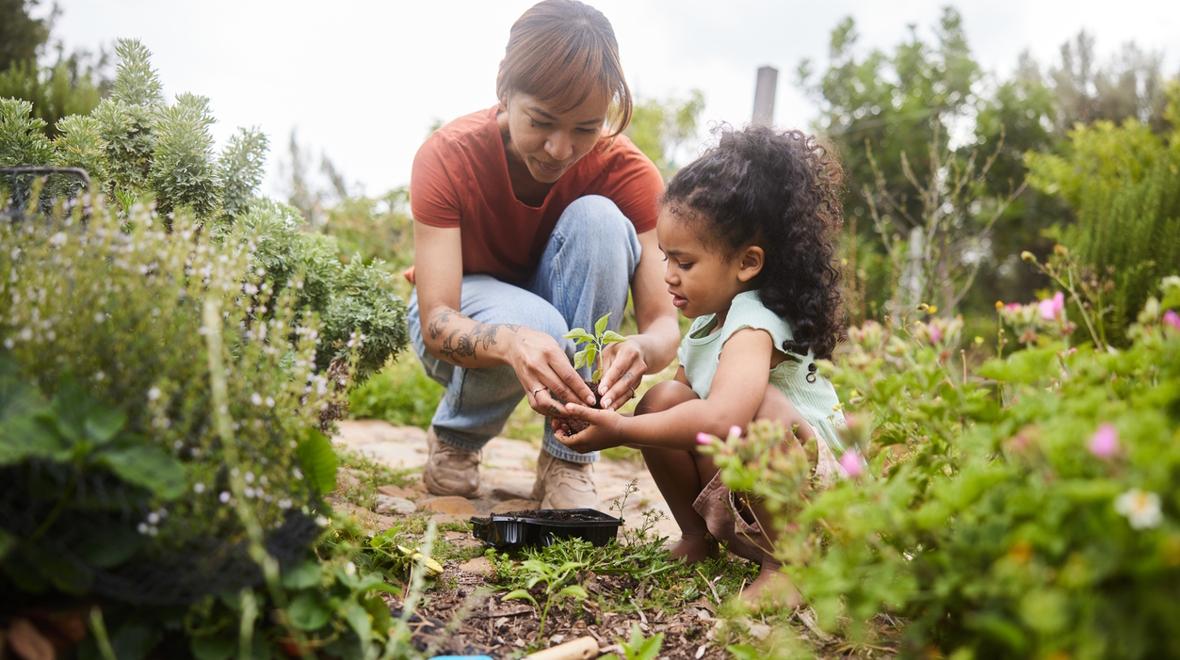 child and adult working in a garden