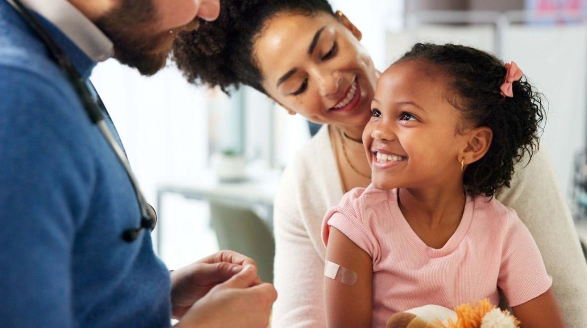 little girl at a primary health checkup with mother and doctor