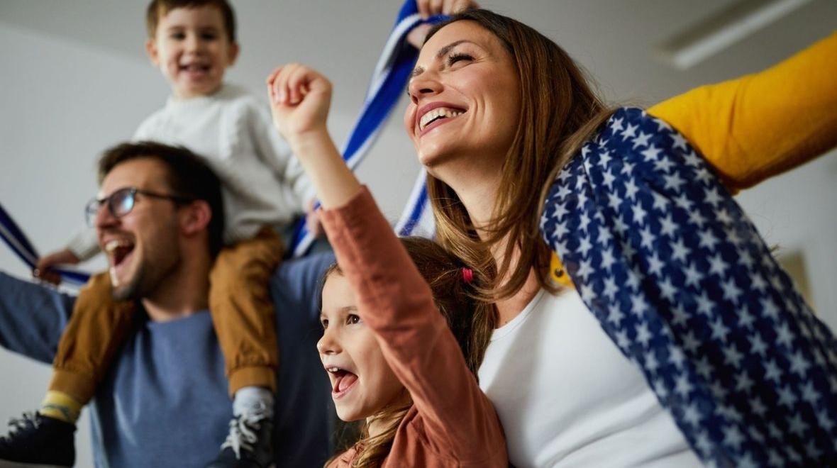 family cheering while watching game at home