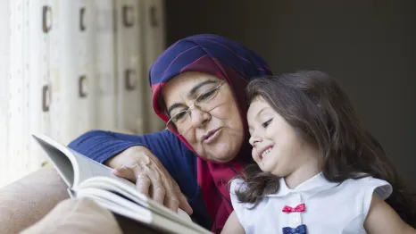 grandmother and granddaughter reading together