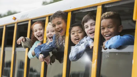 Group of elementary school kids riding the bus to school