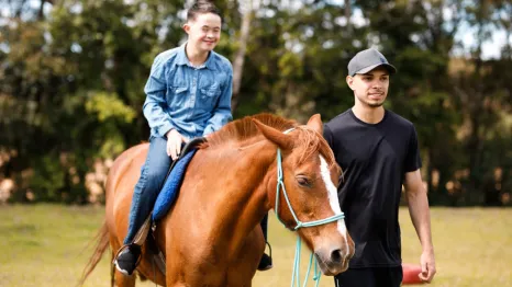 Boy riding a horse at farm animal summer camp in Seattle