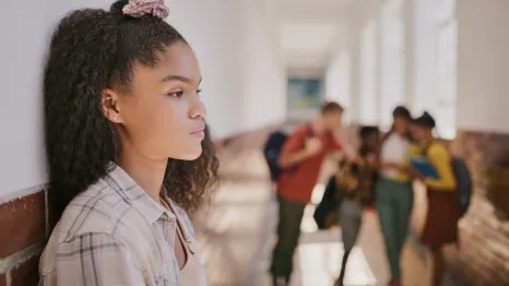 disappointed girl standing in a school hallway