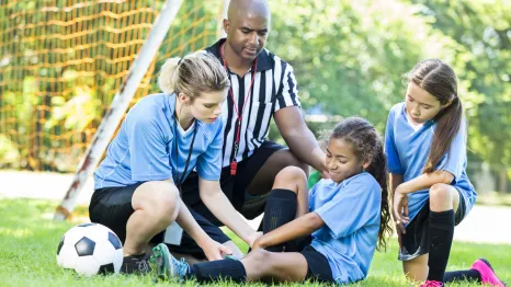 girl playing soccer who has hurt her ankle