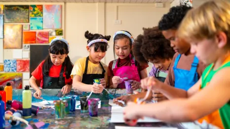 kids sitting around a table engaged in an art project