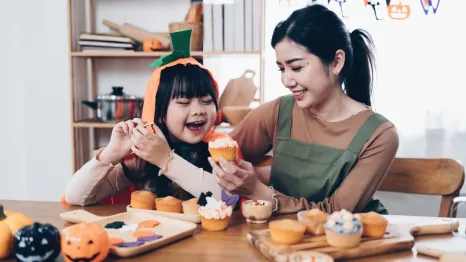 mom and daughter making Halloween treats together