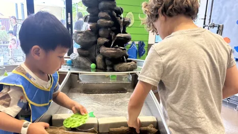 two kids working together at a water exhibit at KidsQuest Children's Museum