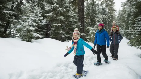 family snowshoeing together