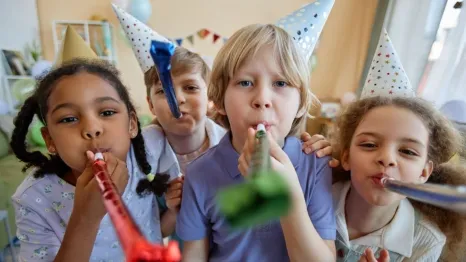 children holding party blowers and having fun