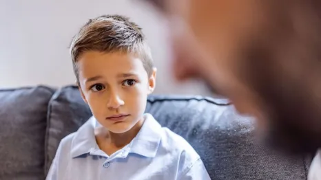 worried little boy talking to adult
