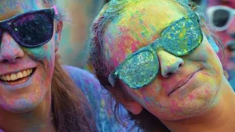 happy people celebrating holy covered in colorful powder