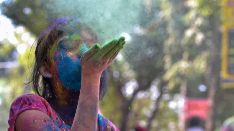 A-girl-blowing-colors-celebrating-holi-colors-best-seattle-area-Holi-events-kids-families-redmond-eastide