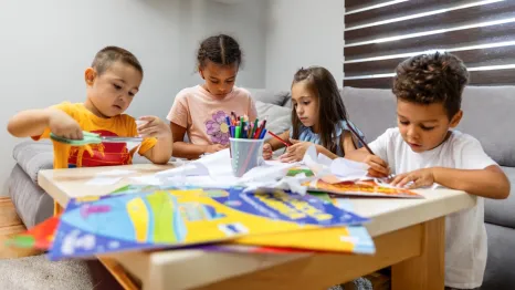 kids sitting around a table doing craft projects