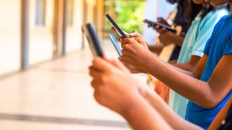 group of children hands busy using smartphone at school corridor