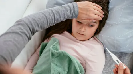 little girl sick checking body temperature with thermometer