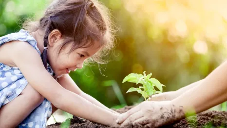 Girl helping plant during Earth Day event