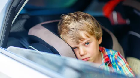 little boy feeling sick in car seat