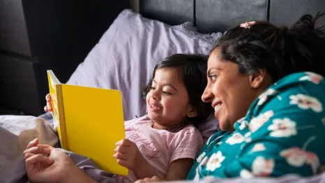 mother with kid reading in bed