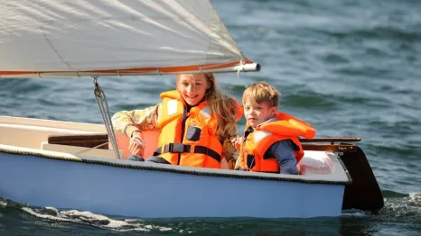 Two kids sailing in small vessel