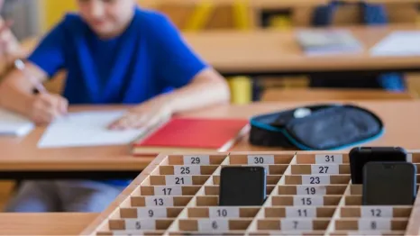 School kids placing putting phones away during class
