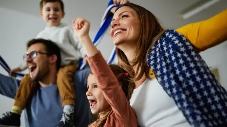 family cheering while watching game at home