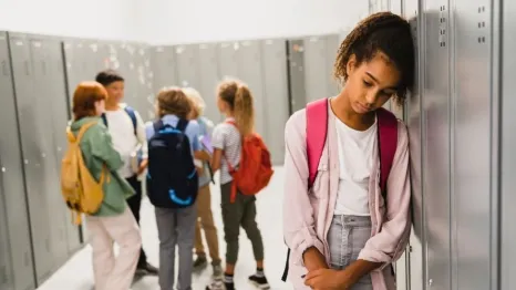 student leaning against locker, looking sad, worried about end of the school year