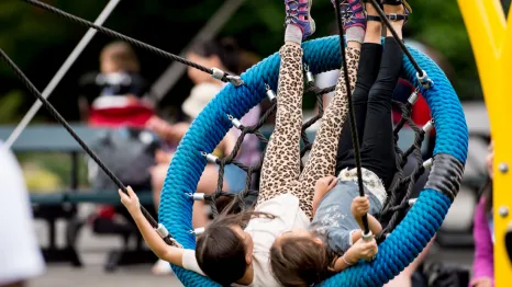 kids swinging on the Artists at Play Playground in Seattle Center, a fun weekend activity for Seattle families