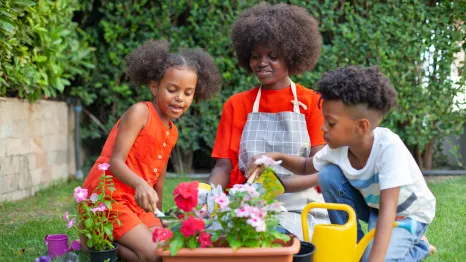 mom and kids planting flowers
