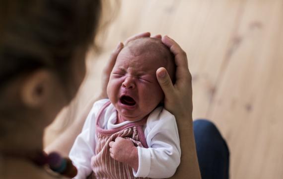 mother holding her crying newborn