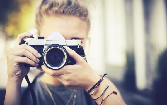 Boy pointing a camera at the viewer