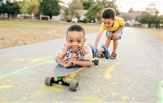 Cute young brothers playing on a skateboard in summer best weekend events activities for Seattle area kids and families