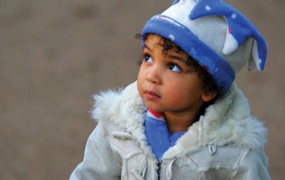Adorable toddler dressed in a winter coat and hat