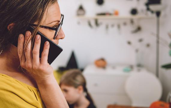 Mom on the phone with child in the background