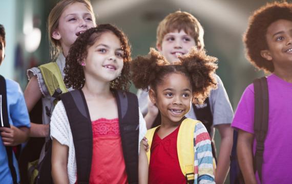 Group of children of different ages wearing backpacks