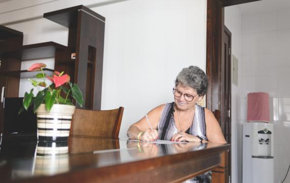 Woman sitting at a table writing a letter