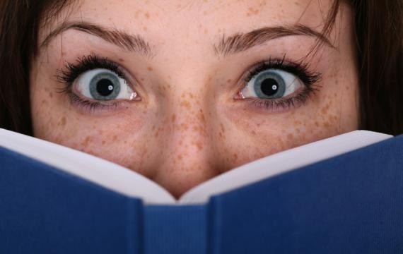 Wide eyes looking out over an open book