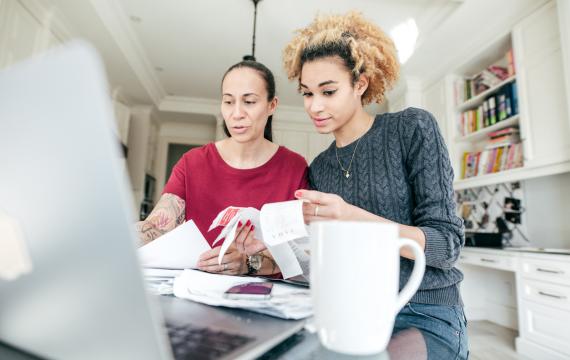 Two women sitting at a computer looking at recipes working on a budget 