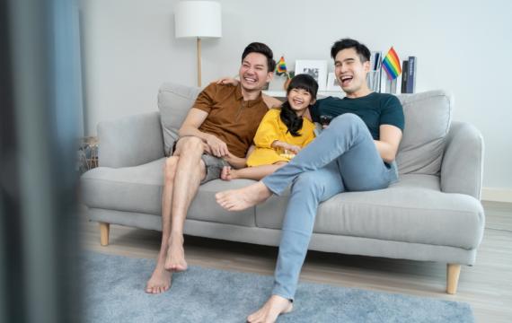 LGBTQ family watching a movie on a couch