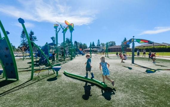 Young kids run on a balance element at the updated and colorful new playground at Emma Yule Park in Everett, near Seattle, best Seattle weekend activities for kids and families