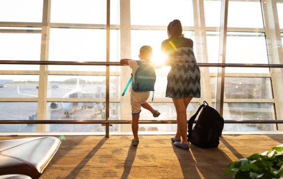 A mom and son look at the window of an airport representing Paine Field in Everett, Wash., near Seattle alternative airport to Sea-Tac