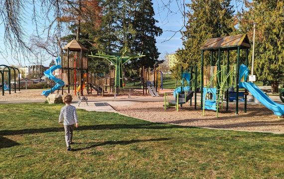 A young boy walks toward the play equipment at Othello Park playground in South Seattle, know for its fast hillside slide